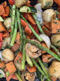 Close-up of roasted vegetables with asparagus, carrots, baby potatoes, mushrooms, and onions