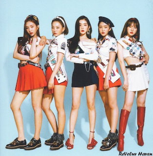 Five young women in matching white tops and colorful skirts posing in a studio portrait
