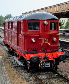 Vintage red tram car on railway tracks at a station platform