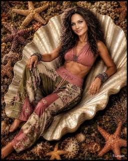 Woman with curly hair reclining in a giant clam shell surrounded by starfish and shells