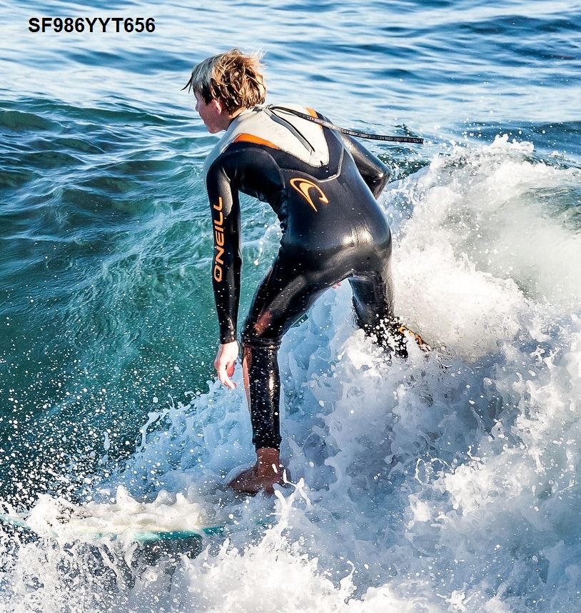 Surfer in a black wetsuit riding a wave in the ocean