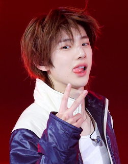 Young performer making a peace sign with tongue out against a red background