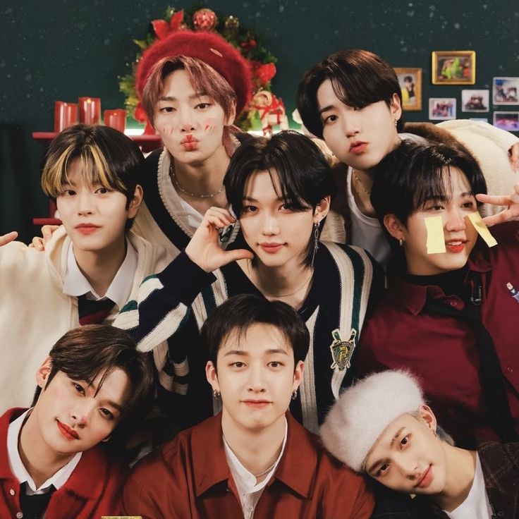 Seven young men posing together indoors with Christmas decorations behind them