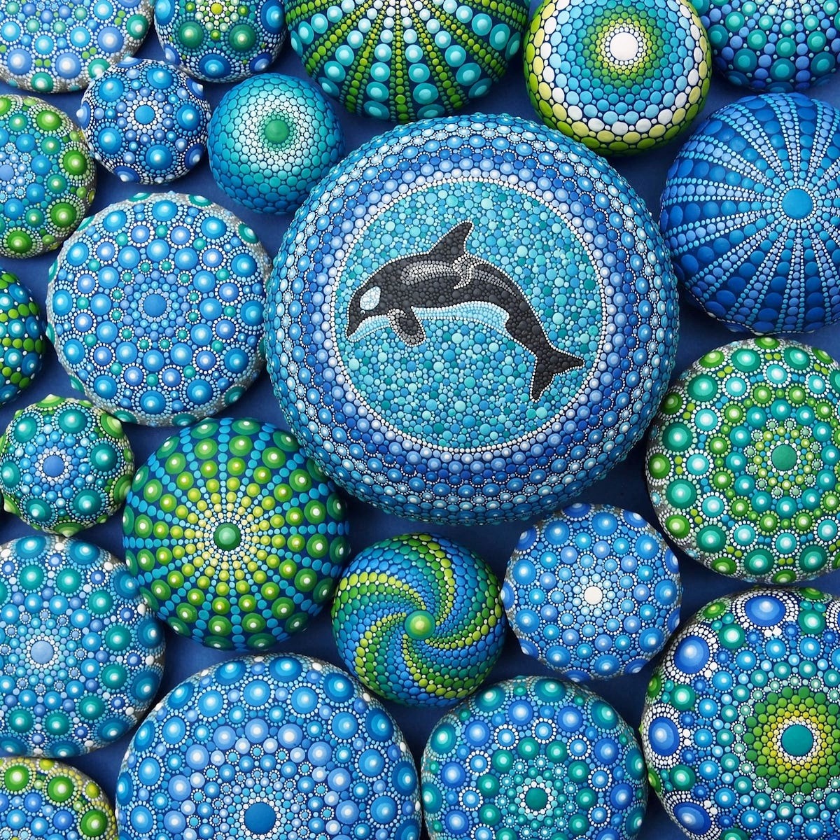 Colorful dot mandala painting with central dolphin motif surrounded by circular geometric patterns in blue and green