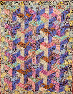 Vibrant patchwork quilt with 3D tumbling blocks pattern in multicolored fabrics and ornate paisley border