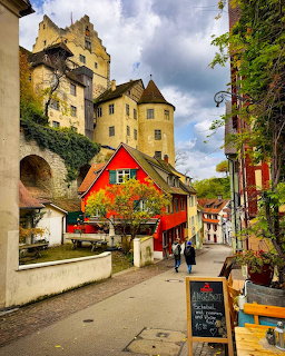 Medieval village street in Meersburg with historic tower, colorful half-timbered houses, and cobblestone path