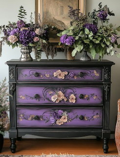 Black dresser with purple floral-painted drawers and flower arrangements on top beneath a mirror