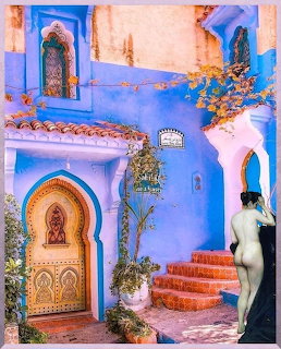 Blue Moroccan courtyard with decorated door, stairs, and figure in black robe