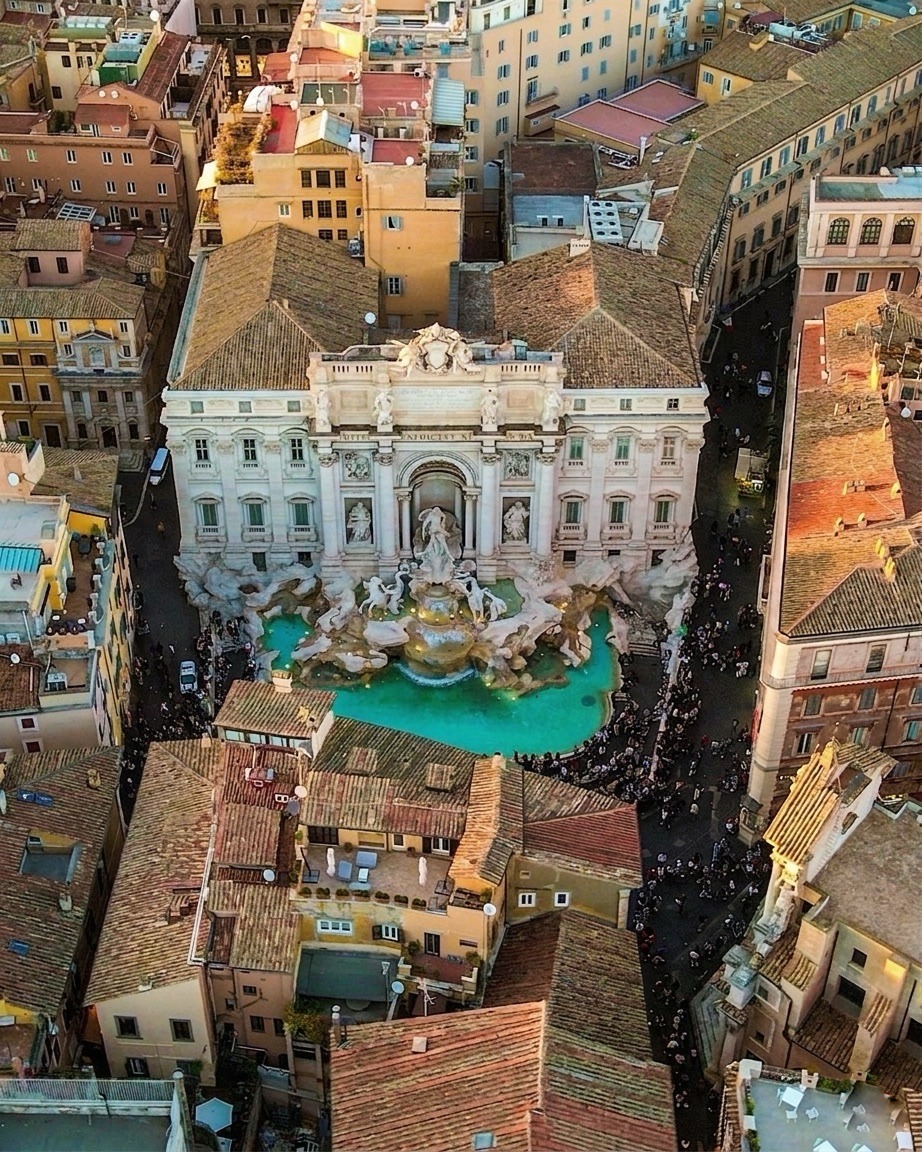 Aerial view of Trevi Fountain surrounded by Roman buildings and crowds