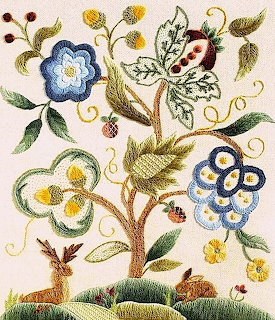 Embroidered tree with blue, yellow, and green decorative flowers and curling vines