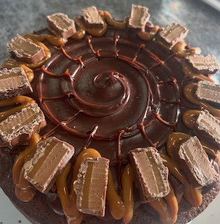 Top view of a chocolate ganache cake topped with wafer candy pieces and caramel drizzle