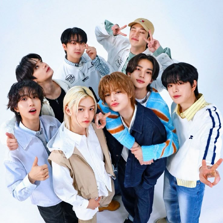 Eight young men in casual clothing posing together looking upward in a studio group portrait