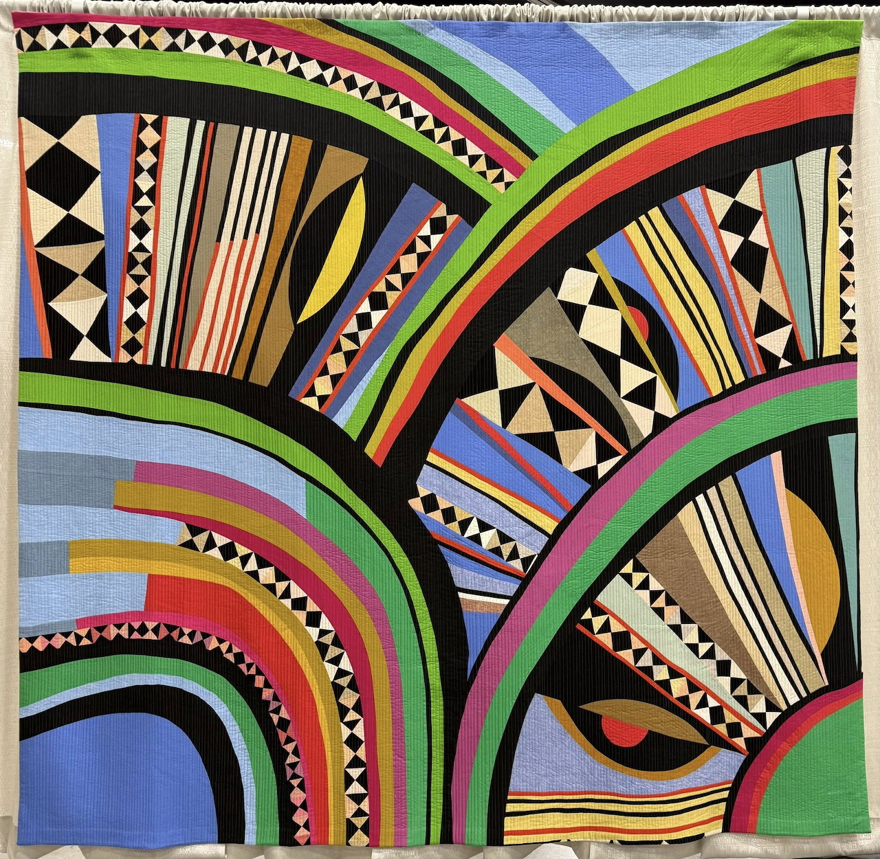 Colorful abstract quilt pattern with curved bands and geometric patchwork shapes