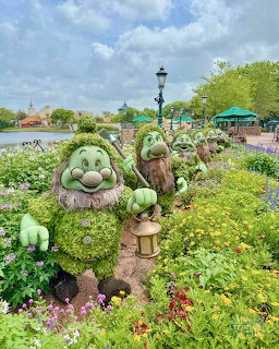Seven Dwarfs plant topiaries in Disney garden with colorful flowers