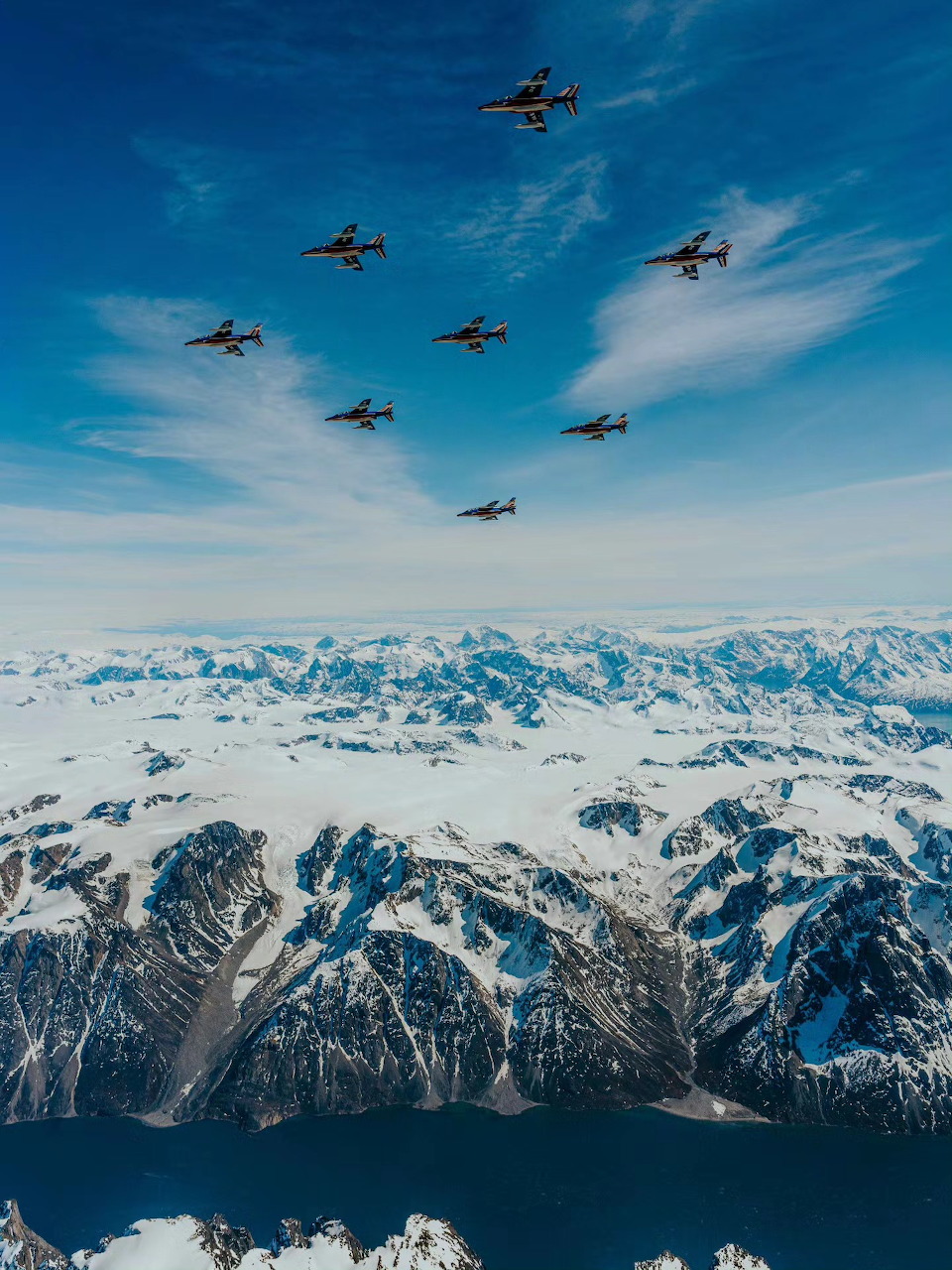 Patrouille de France jets flying in formation over snowy Alpine mountain range