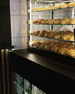 Glass bakery case filled with croissants and pastries in a cafe