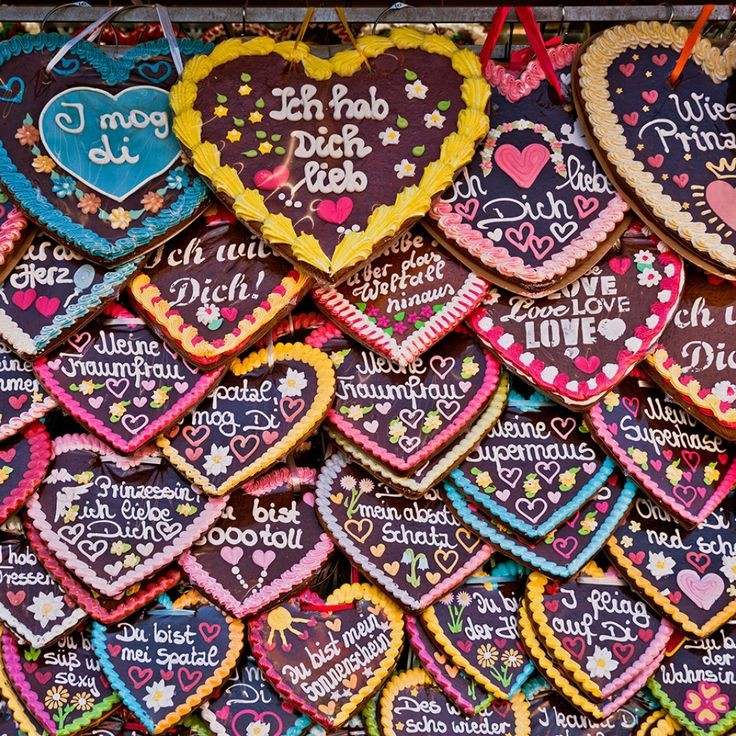 Colorful gingerbread heart cookies with icing messages hanging and stacked together