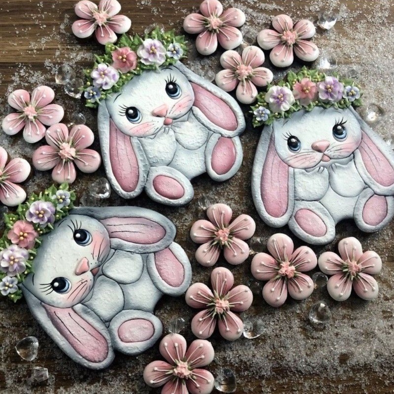 Easter bunny and flower shaped cookies with pink and white icing on wooden surface