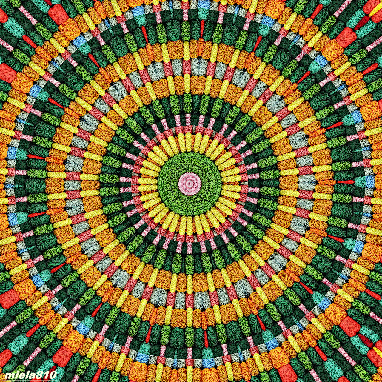 Colorful concentric circular mandala pattern with radiating segments in green, orange, yellow, pink, and blue