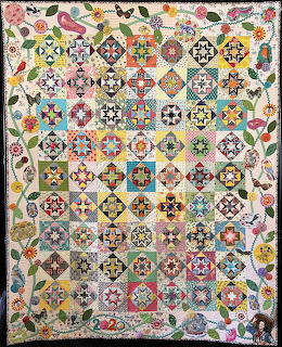 Colorful patchwork quilt with geometric patterns and floral border