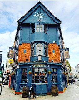 Blue Victorian corner pub building with orange brick details and large windows in Camden, London