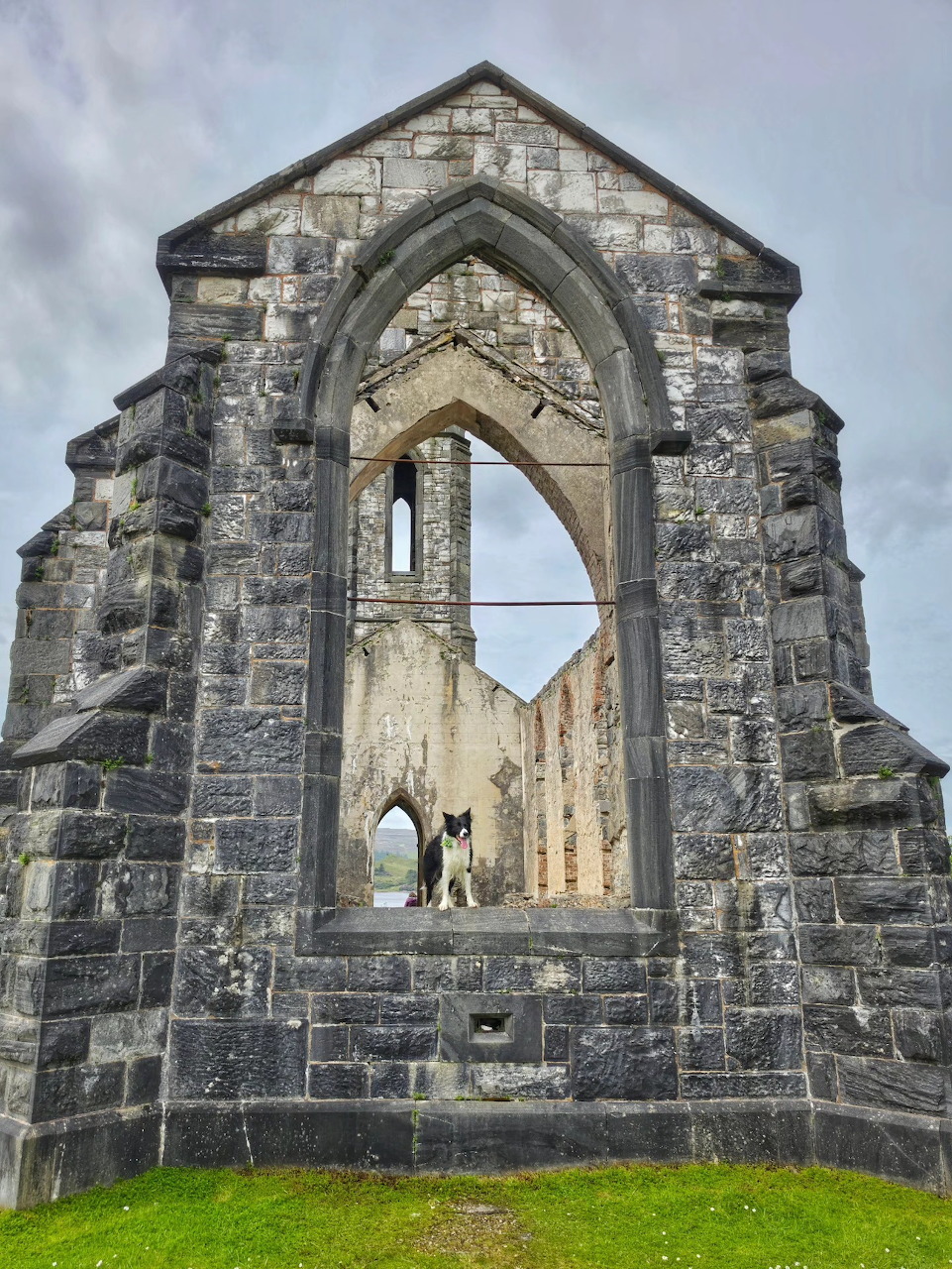 Old stone church ruins with a Gothic arch and grassy foreground