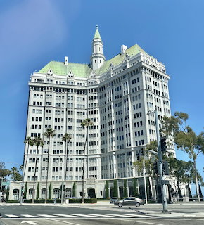 Historic Breakers hotel building in Long Beach CA with green copper roof and clock tower
