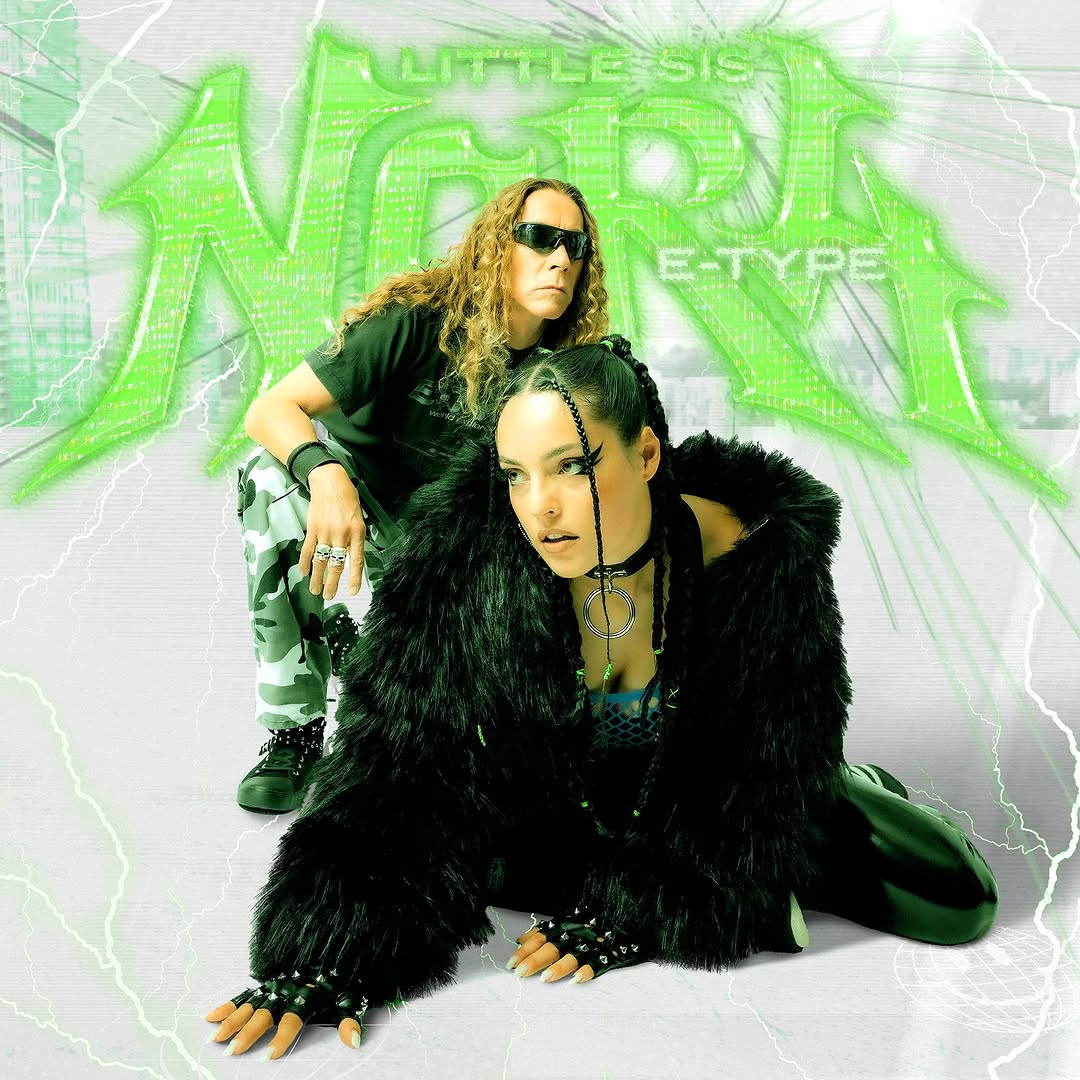 Two performers in black outfits pose in front of green graffiti text with lightning effects