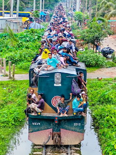 Overcrowded passenger train in Bangladesh with people covering the entire roof and sides