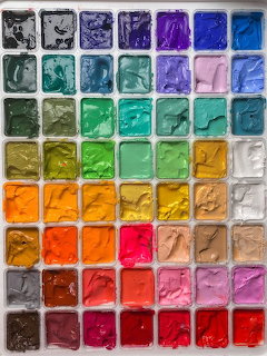 Grid of square paint wells filled with many different colors of paint arranged in rows