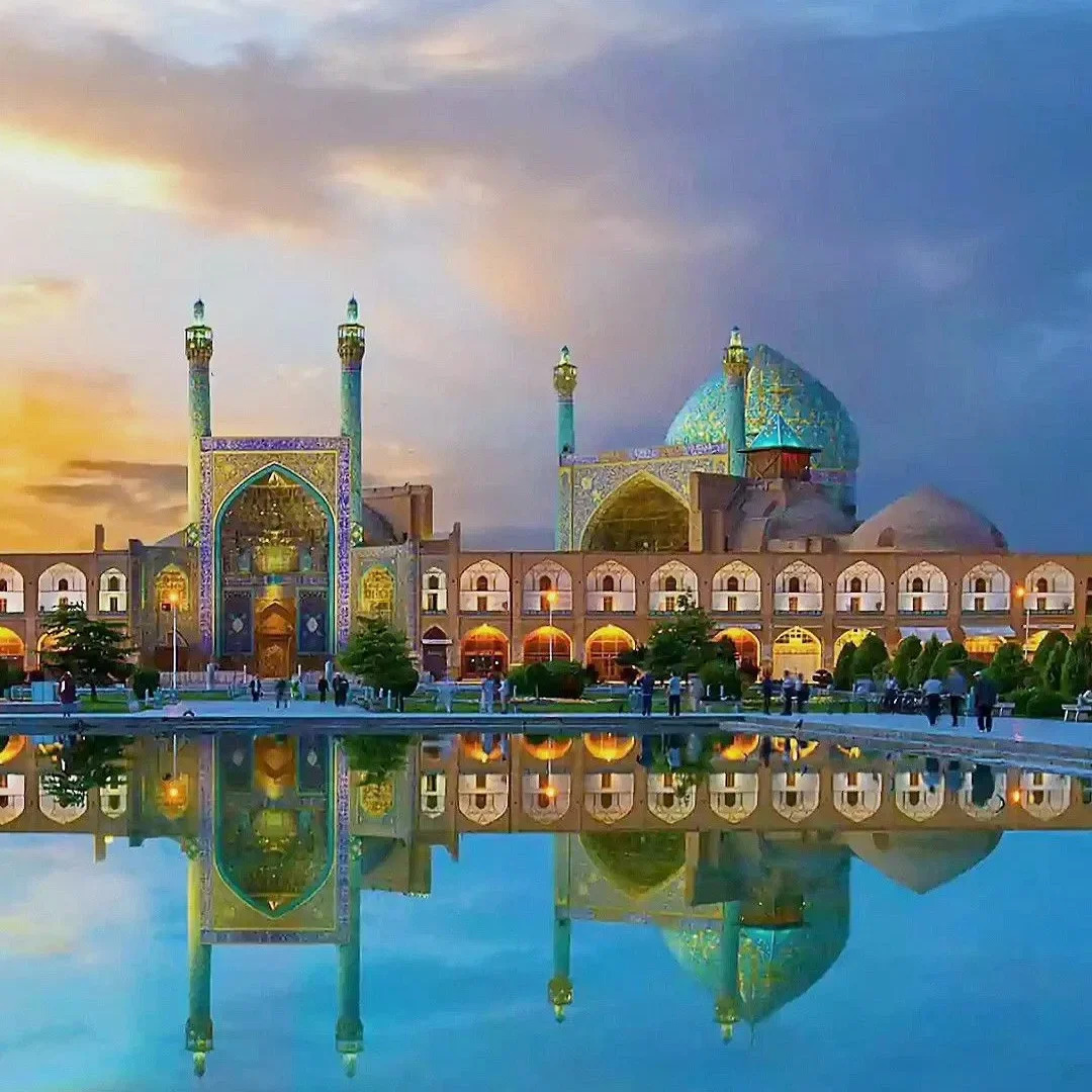 Blue mosque with domes and minarets reflected in a pool at sunset