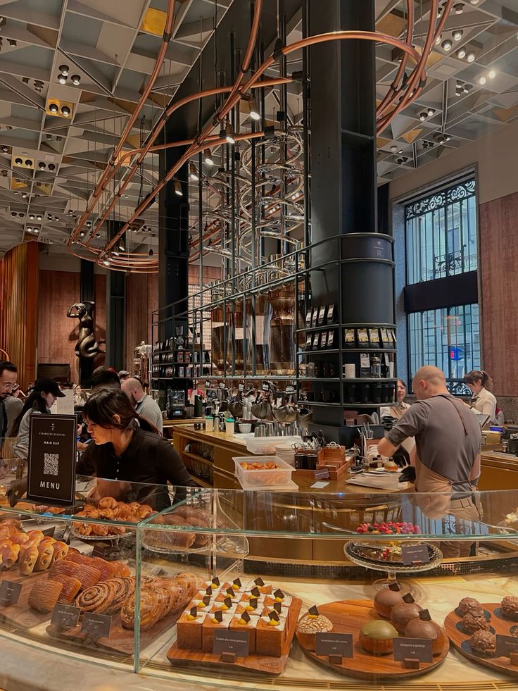 Starbucks Reserve Roastery interior with pastry display case, baristas, and copper pipe ceiling decor
