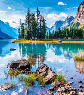 Scenic mountain lake with island and rocky shore under blue sky