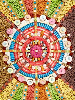 Circular mandala pattern made from colorful cereal loops, candies, cookies and other sweets arranged symmetrically