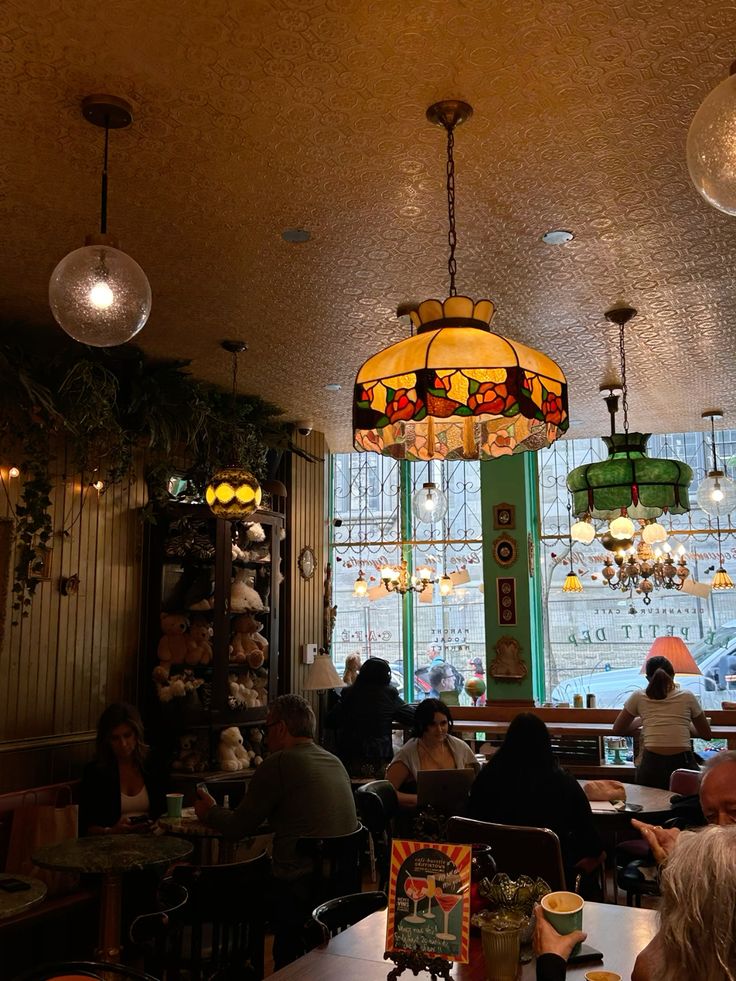 Cafe interior with colorful stained glass hanging lamps over tables and seated patrons