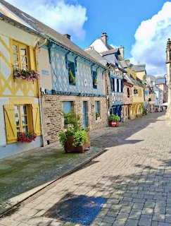 Colorful half-timbered houses along cobblestone street in Josselin, Brittany, France