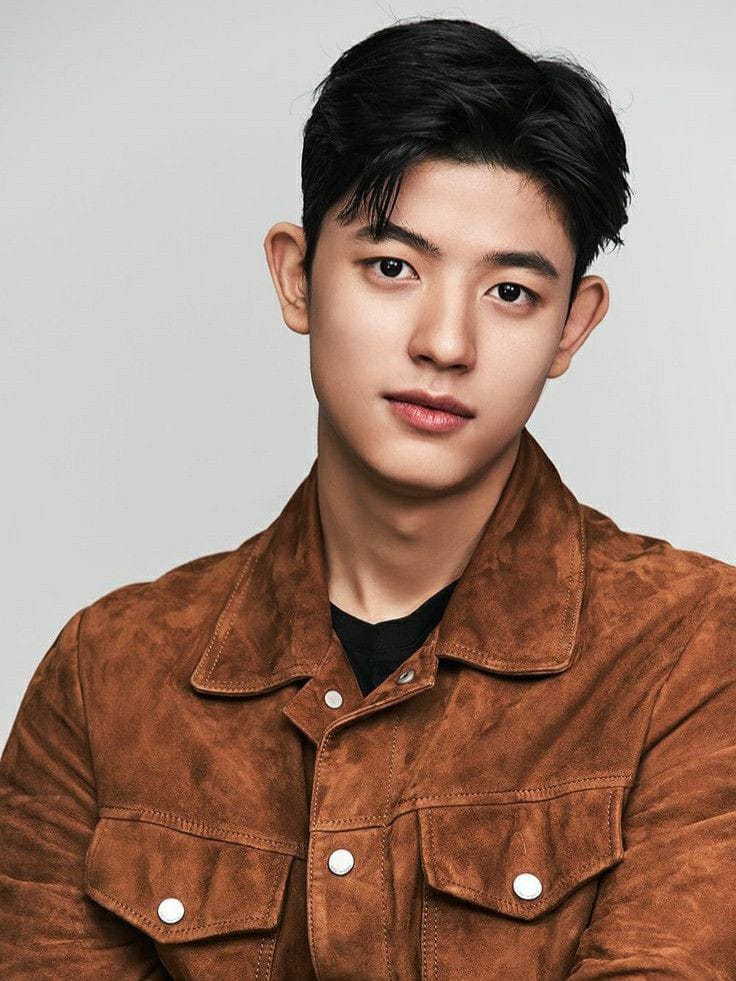 Young Asian man with dark hair in a brown suede jacket, professional portrait photo