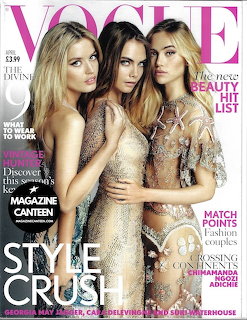 Vogue magazine cover with three women posing closely together in sparkly and elegant attire
