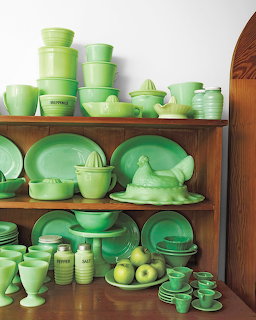 Wooden hutch displaying a large collection of green jadeite glassware and kitchen dishes