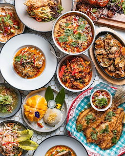 Overhead flatlay of diverse brunch dishes on white plates with colorful food including salads, meats, soups, and desserts