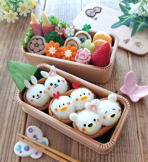 Bento box with kawaii animal rice balls and colorful food decorations
