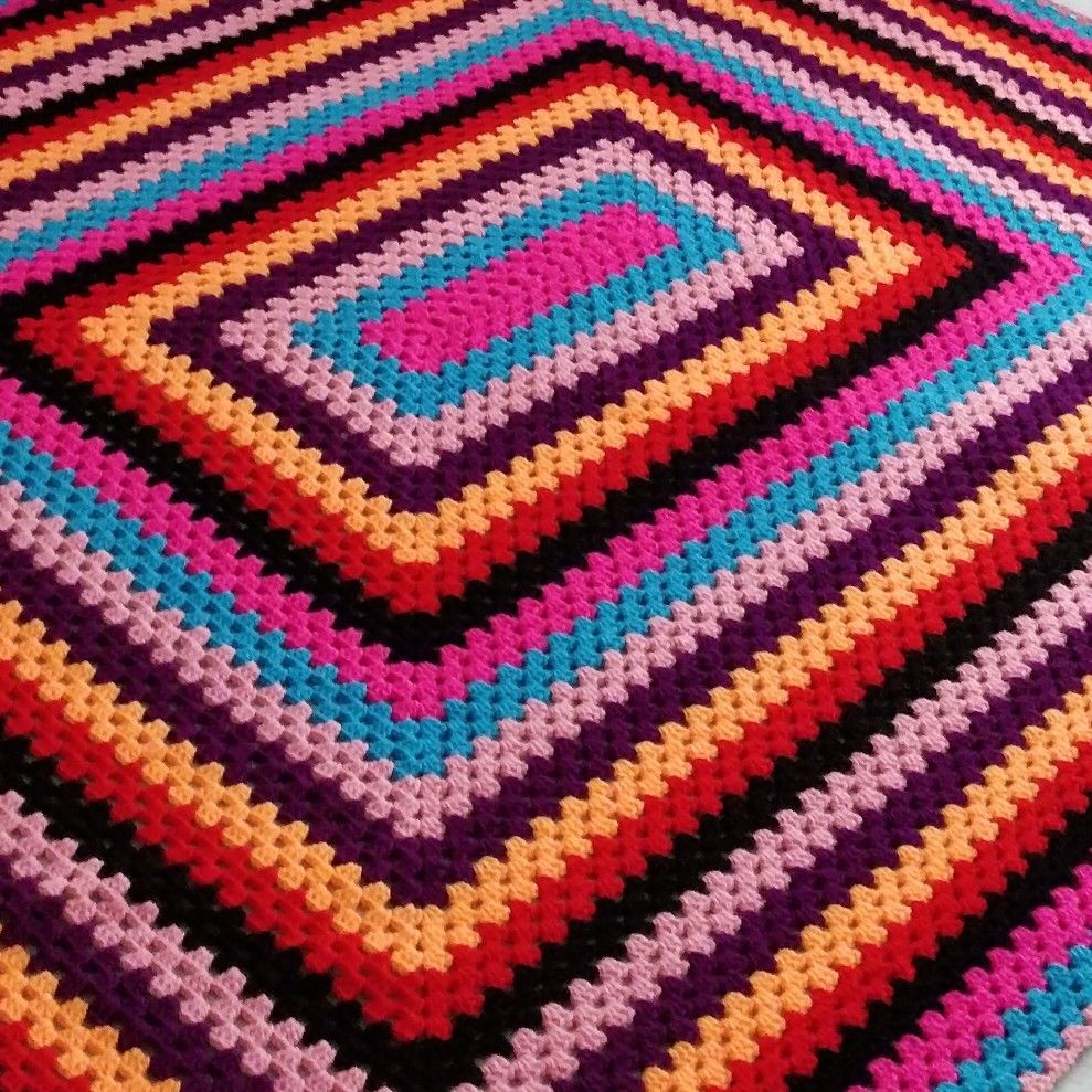 Close-up of a colorful crocheted diamond pattern in pink, blue, purple, orange, and black
