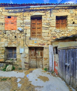 Weathered stone building with wooden doors and windows in Navafria, Spain