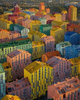 Aerial view of colorful apartment buildings packed closely together in a city neighborhood