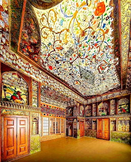 Ornate Iranian interior with painted ceiling, decorative panels, and stained glass windows in traditional Persian style