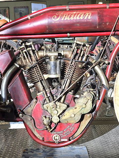 Vintage Indian motorcycle showing red fuel tank with chrome Indian script and detailed V-twin engine