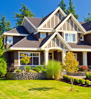 Two-story suburban house with beige siding, brown trim, and landscaped front yard