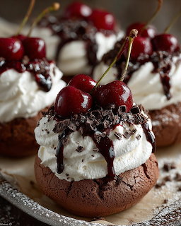 Chocolate desserts topped with whipped cream, chocolate drizzle, and fresh cherries on a dark surface
