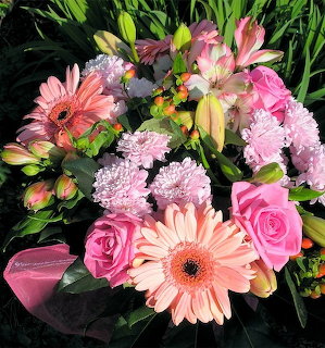 Colorful pink flower bouquet with gerbera daisies, roses, chrysanthemums, and lilies on green grass