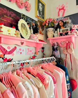 Pink coquette bedroom with clothing rack, heart-shaped shelf, and feminine decorations